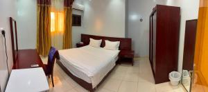 a bedroom with a bed with white sheets and pillows at Al Samia economy apartment in Baljurashi