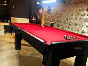 a woman playing a game of pool on a pool table at Hotel Sinhá in Tianguá