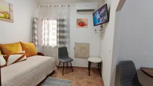a small living room with a couch and a tv at Casa Lotus in Aljezur