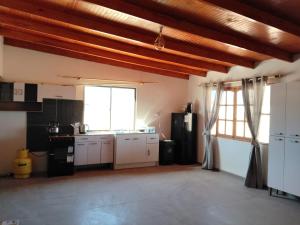 a kitchen with white cabinets and a large window at Casa Atitur in San Pedro de Atacama