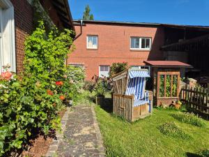 a yard with a blue and white chair and flowers at Abendsonne in Wurster Nordseeküste