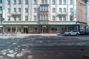 a large white building with cars parked in front of it at Juno Hotel Bremen City in Bremen