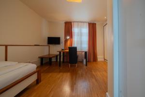 a bedroom with a bed and a desk with a television at Juno Hotel Bremen City in Bremen