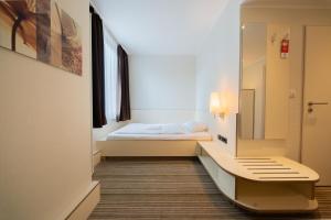 a hospital room with a bed and a mirror at Juno Hotel Bremen City in Bremen