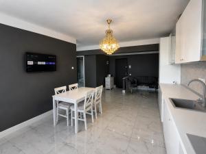 a kitchen and dining room with a white table and chairs at YDA Apartament's in Baciu +5 photos