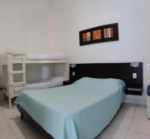 a bedroom with a bed and bunk beds in it at Hotel Del Parque in Corrientes