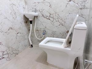 a bathroom with a white toilet and a sink at Hotel Drip inn JNK in Lucknow +24 photos