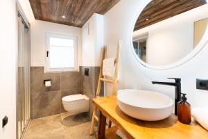 a bathroom with a sink and a toilet and a mirror at Bramberg Hideaway mit großer Terrasse in Größing +36 photos