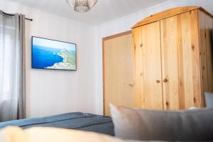 a bedroom with a bed and a wooden cabinet at Bramberg Hideaway mit großer Terrasse in Größing