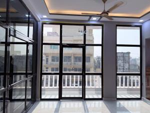 an empty room with windows and a ceiling fan at Hotel Drip inn JNK in Lucknow
