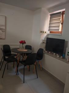 ein Esszimmer mit Tisch, Stühlen und Flachbildfernseher in der Unterkunft ZAD Senj Apartman in Senj