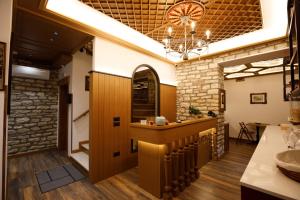 a kitchen with a bar and a stone wall at Vila Mantho in Gjirokastër