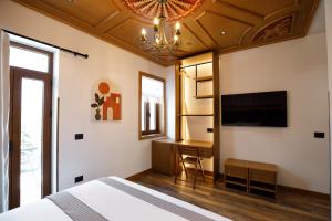 a bedroom with a bed and a desk and a chandelier at Vila Mantho in Gjirokastër