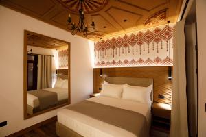 a bedroom with a large bed and a mirror at Vila Mantho in Gjirokastër +71 photos