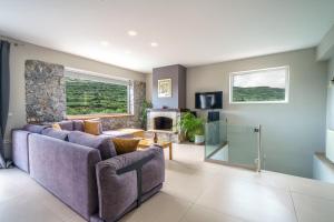 a living room with a purple couch and a fireplace at Petronila Luxury Villa with heated private pool in Kissamos