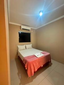 a bedroom with a bed with a red blanket at Hotel Matrin in Barretos