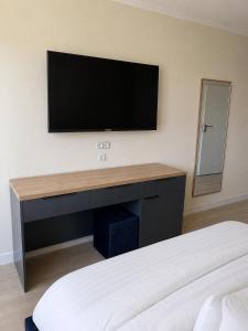 a bedroom with a flat screen tv on the wall at Nordsee-Hotel in Butjadingen