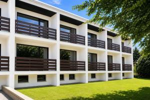 an exterior view of a white building with wooden balconies at Nordsee-Hotel in Butjadingen