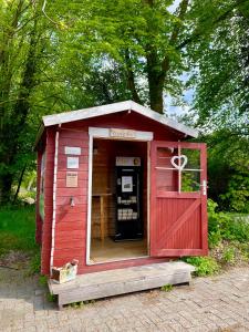 a red out house with a door open at Nordsee-Hotel in Butjadingen
