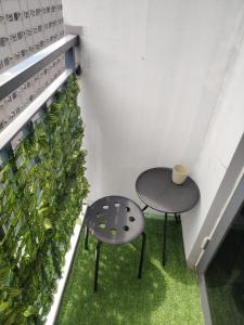 two tables in a room with a plant at Casa Hiraya - Shore 2 Tower 2 in Manila