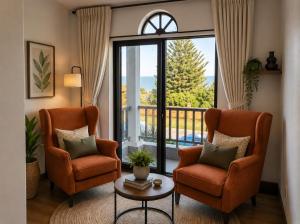 a living room with two chairs and a large window at ACRE on Albatros in Gqeberha