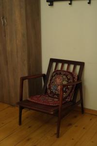 a wooden chair with a pillow sitting on a wooden floor at Hotel Lemi in Mestia