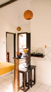 a kitchen with a table in a room at Pousada Aconchego do Rosa - Centrinho do Rosa in Praia do Rosa