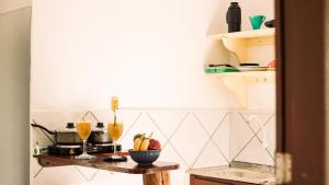 a kitchen with a table with fruit on it at Pousada Aconchego do Rosa - Centrinho do Rosa in Praia do Rosa +35 photos