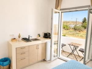 eine Küche mit Spüle und einer Tür zur Terrasse in der Unterkunft Aqualis in Adamas