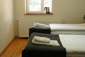 two beds in a room with two ottomans sidx sidx sidx at Hotel Lemi in Mestia