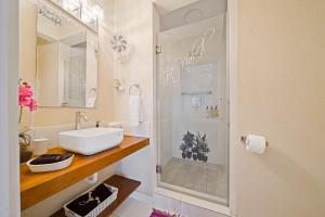 a bathroom with a shower with a sink and a mirror at Hidden Gem The Serenity - by ZenBreak in Christ Church +21 photos