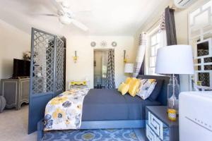 a bedroom with a blue bed and yellow pillows at Hidden Gem The Serenity - by ZenBreak in Christ Church
