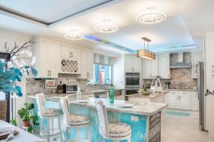 a kitchen with white cabinets and a island with bar stools at Hidden Gem The Moroccan - by ZenBreak in Christ Church