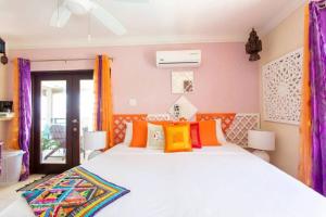 a bedroom with a large bed with colorful pillows at Hidden Gem The Moroccan - by ZenBreak in Christ Church