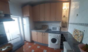 a kitchen with a washing machine and a microwave at Mallona in Pedro Rodríguez +10 photos