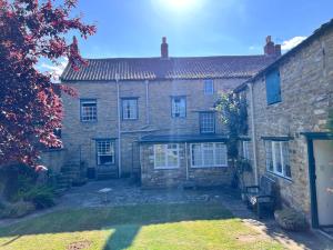 an old brick house with a yard in front of it at Towler's Chemist in Kirkbymoorside