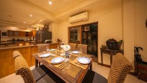 a dining room with a wooden table and chairs at Orchid House Pattaya, Totally Private Pool in Pattaya South