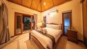 a bedroom with a bed with a stuffed animal on it at Orchid House Pattaya, Totally Private Pool in Pattaya South +48 photos