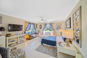 a bedroom with a blue bed and a living room at Hidden Gem The Parisian - by ZenBreak in Christ Church