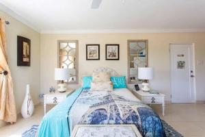 a bedroom with a bed and two tables and two lamps at Hidden Gem The Parisian - by ZenBreak in Christ Church +19 photos