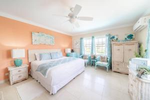 a bedroom with a bed and a ceiling fan at Hidden Gem The Tropical - by ZenBreak in Christ Church