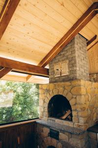a stone fireplace in a porch with a wooden roof at Апартаменти Helleborus in Staryy Mizunʼ