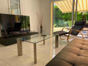 a living room with a glass table and a couch at Villa dolce vita in Murten