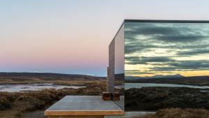 a glass house on top of a hill with a view at Mystic Light Lodge in Búðardalur
