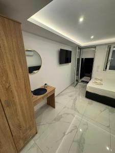 a bedroom with a bed and a desk and a television at Premium Studio Family in Paralia Katerinis