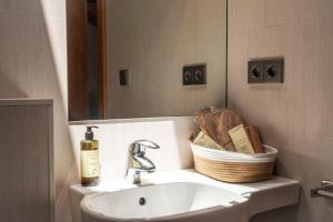 a bathroom sink with a basket and a mirror at Hotel Casa Azcona in Zizur Mayor