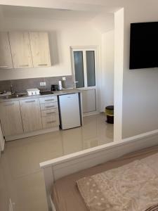 a kitchen with white cabinets and a white refrigerator at Kucice MMM in Donji Štoj