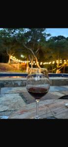 a glass of red wine sitting on a table at Hotel Sinhá in Tianguá