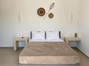 ein Schlafzimmer mit einem großen Bett und zwei Tischen in der Unterkunft Aqualis in Adamas