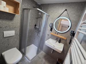 a bathroom with a shower and a sink and a mirror at Aparthotel Fairschlafen Minden in Minden